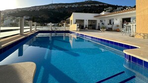 Una piscina con una vista despejada de una colina al fondo.