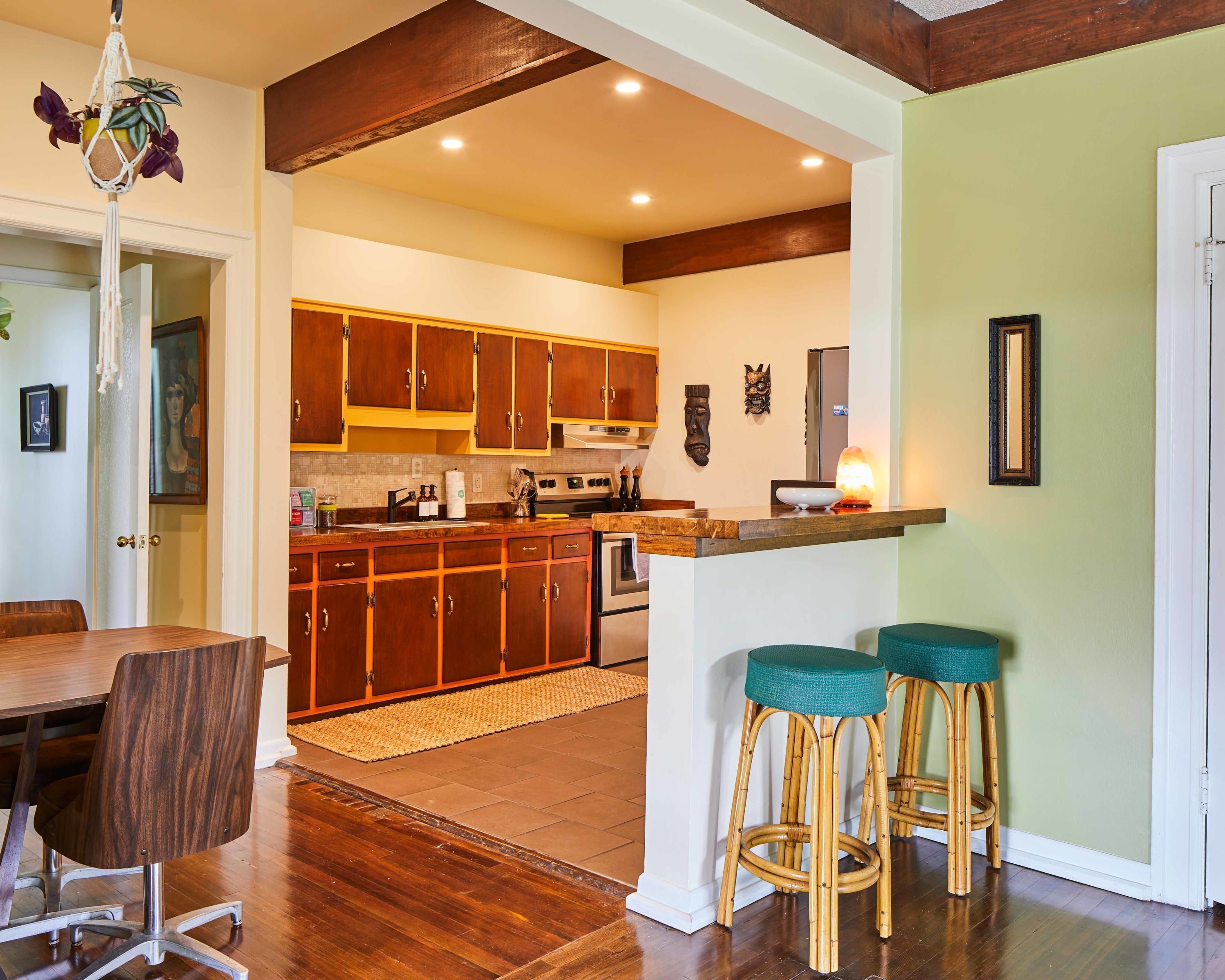 Una cocina moderna con armarios de madera, una isla central y taburetes de bar.