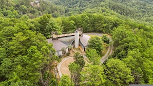 A remote, forested area with a small building featuring a circular roof and a chimney. - Belltop Architectural Wonder on Private Mountain (Sevierville)