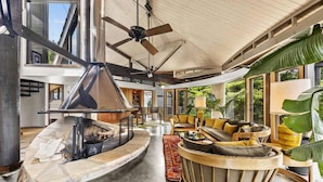 A spacious living area with a fireplace, comfortable seating, and large windows offering views of the outdoors. - Belltop Architectural Wonder on Private Mountain (Sevierville)