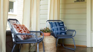 A porch with two wicker chairs, a potted plant, and a sign indicating apartment locations. - Apt3 Charles - Modern Fun Sun-filled Loft (Birmingham)