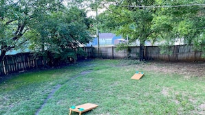 A backyard with a wooden play structure, a wooden fence, and trees. - Blue Door Walk to Avondale Dog-friendly w Yard (Birmingham)