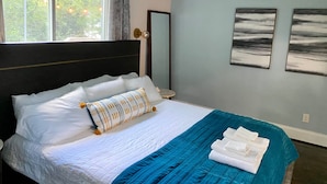 A bedroom with a bed, a ceiling fan, a window with curtains, and two wall-mounted paintings. - Blue Door Walk to Avondale Dog-friendly w Yard (Birmingham)