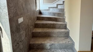 A marble staircase leading to a landing with a light switch and a power outlet. - Crown Residence Luxury 2BR in Ljubljana Downtown (Ljubljana)