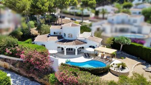 A large, white villa with a tiled roof, a swimming pool, and a covered patio area. - 3 Bedroom Villa Walking Distance to Moraira (Teulada)