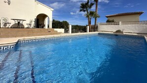 A swimming pool with a geometric tile pattern, a patio area with outdoor furniture, and a palm tree. - Three Bedroom Villa With Private Pool in Moraira (Teulada)