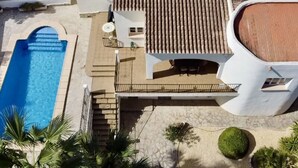 A two-story house with a swimming pool, a patio with outdoor furniture, and a garden. - Three Bedroom Villa With Private Pool in Moraira (Teulada)