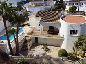 A two-story house with a swimming pool, a patio with outdoor furniture, and a small garden area. - Three Bedroom Villa With Private Pool in Moraira (Teulada)