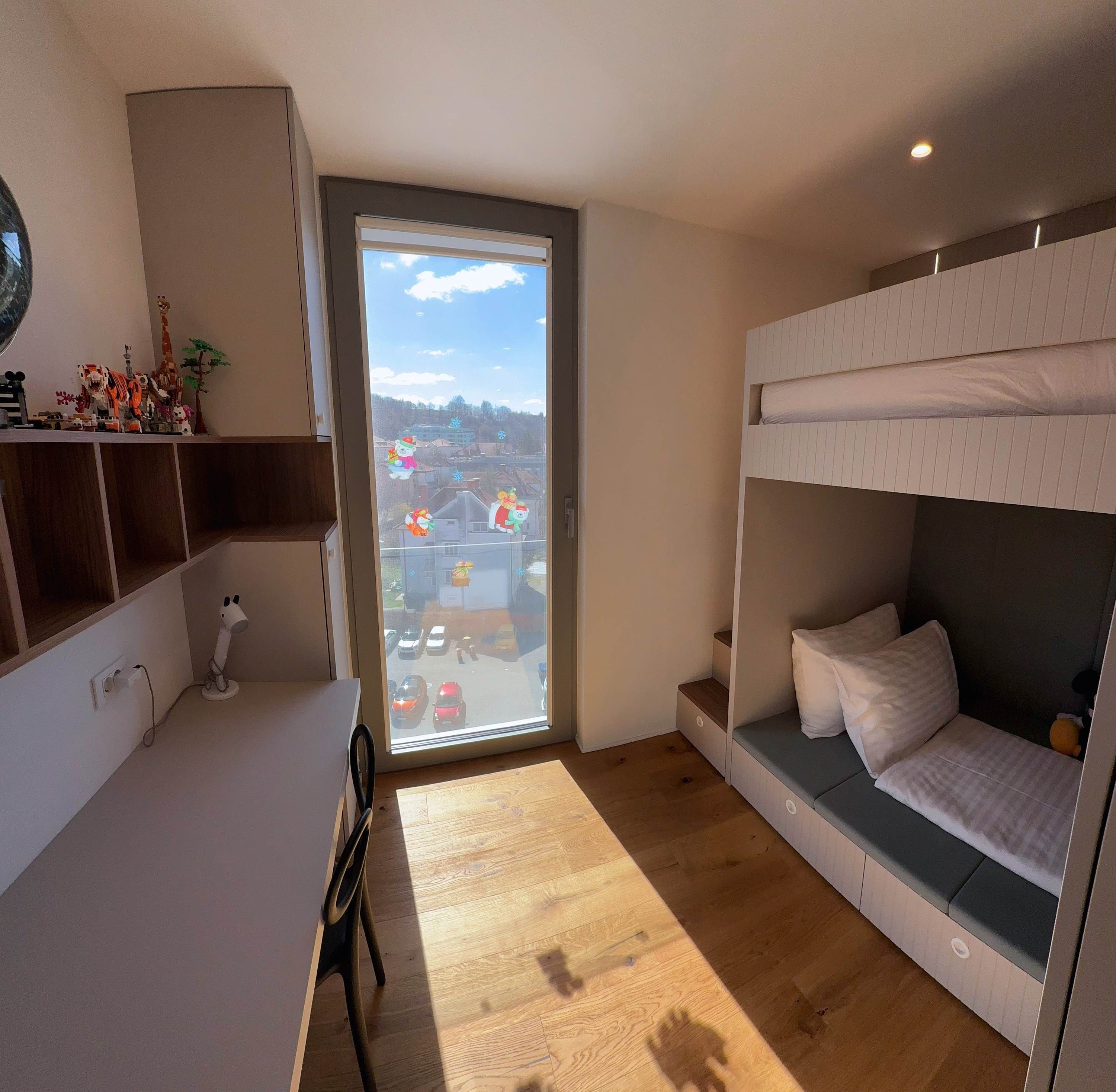 Une petite pièce comprenant un lit superposé, un bureau et une chaise.
