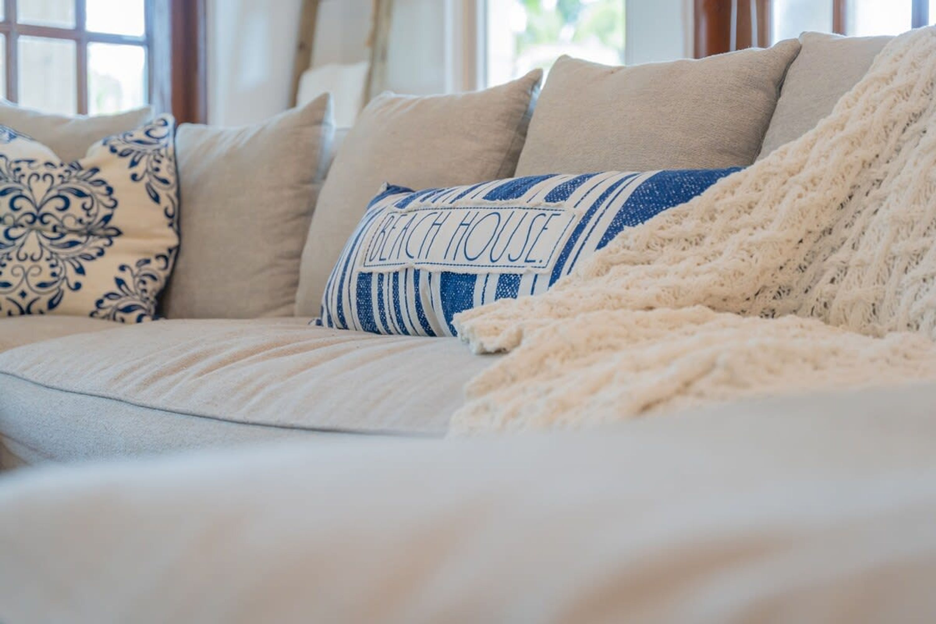 A cozy living room with a sofa adorned with patterned pillows and a knitted throw.