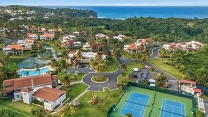 Un quartier résidentiel avec des maisons, un court de tennis et une piscine.
