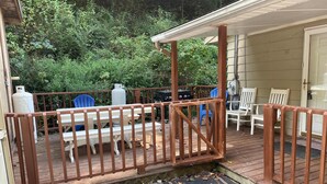 A wooden deck with a table and chairs, surrounded by a wooden railing.