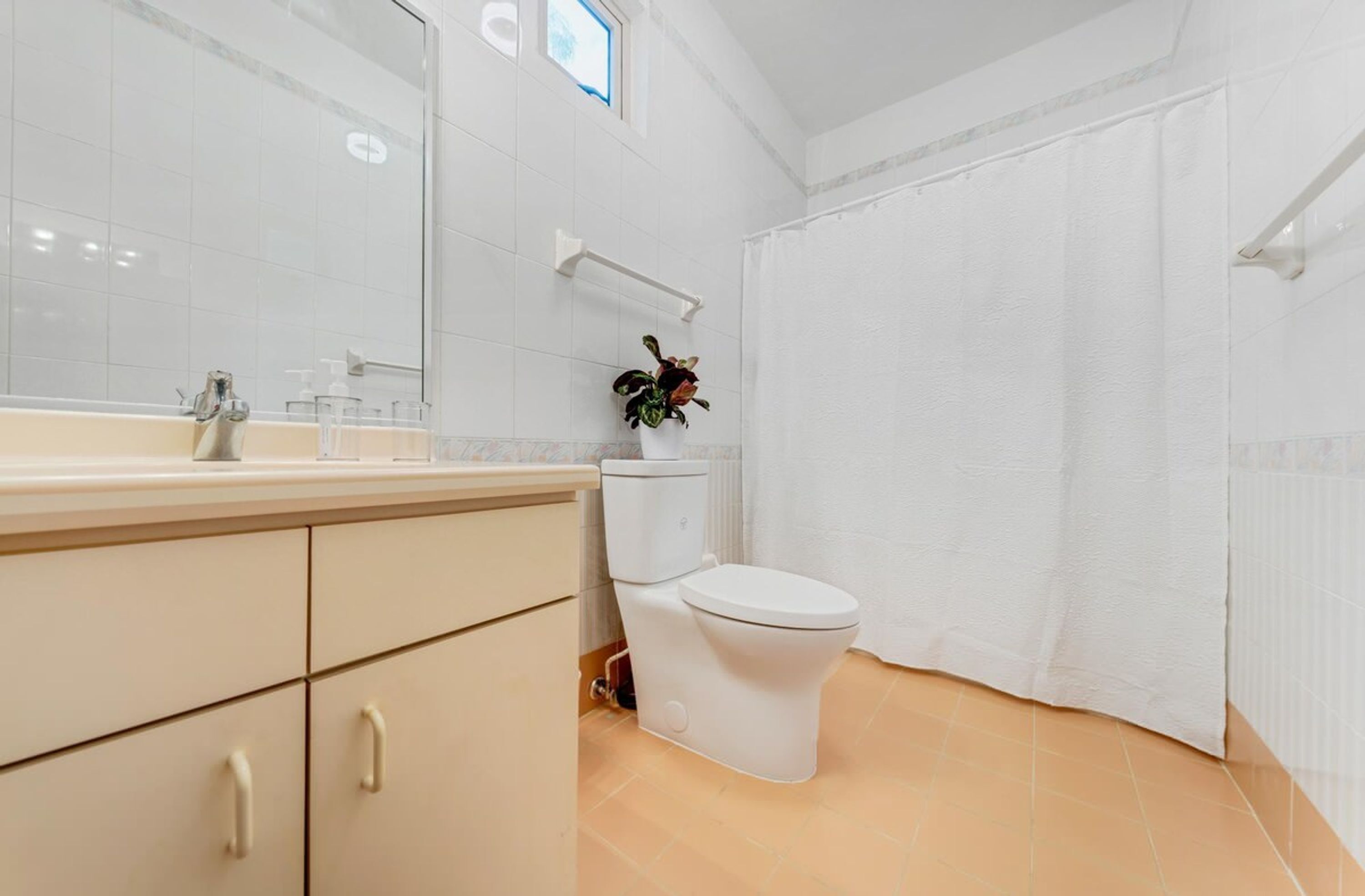 A modern bathroom with a toilet, sink, and mirror.