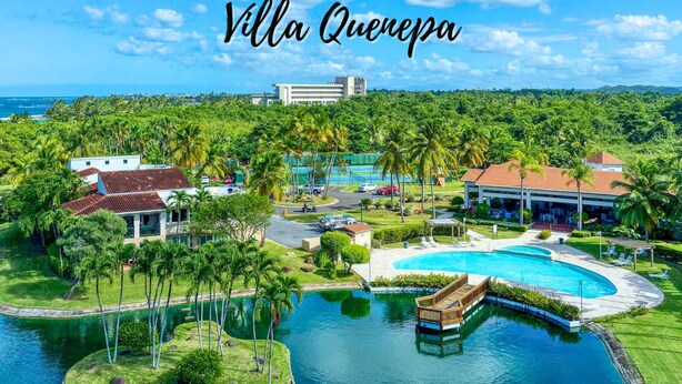 Villa Quevepa with a large swimming pool, lush greenery, and a view of the ocean. - Villa Quenepa at Lakeside Villas (Vega Alta)