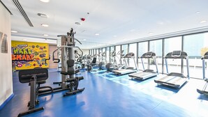 A gym with treadmills, weight machines, and a motivational poster on the wall. - Luxurious Studio With Bay View in Sol Bay (Dubai)