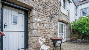 Un bâtiment en pierre avec une porte blanche et une enseigne sur laquelle on peut lire « THE STABLE ».