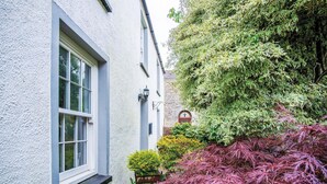 A white building with a window and a stone wall. - Hall House 3 Bedroom House St Florence (Tenby)