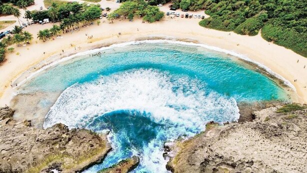 An aerial view of a beach with clear turquoise waters, rocky formations, and a sandy shoreline. - 4 BR Kikita Beach Villa Oceanfront w Pool (Dorado)