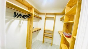 A walk-in closet with wooden shelving and a metal rack. - Gentlemen s Suite 3 Bedroom (Georgetown)