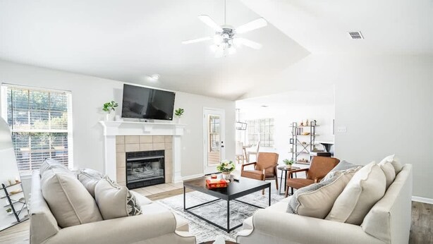A modern living room with a fireplace, two sofas, a coffee table, and a TV. - Pool Oasis w King Bed Firepit (Cabot)