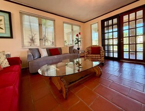 A living room with a sofa, armchair, and glass coffee table. - Villa De Palma - Oceanfront Community w Generator (Vega Alta)