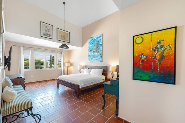 A bedroom with a bed, bedside tables, a bench, and artwork on the walls. - Villa De Palma - Oceanfront Community w Generator (Vega Alta)