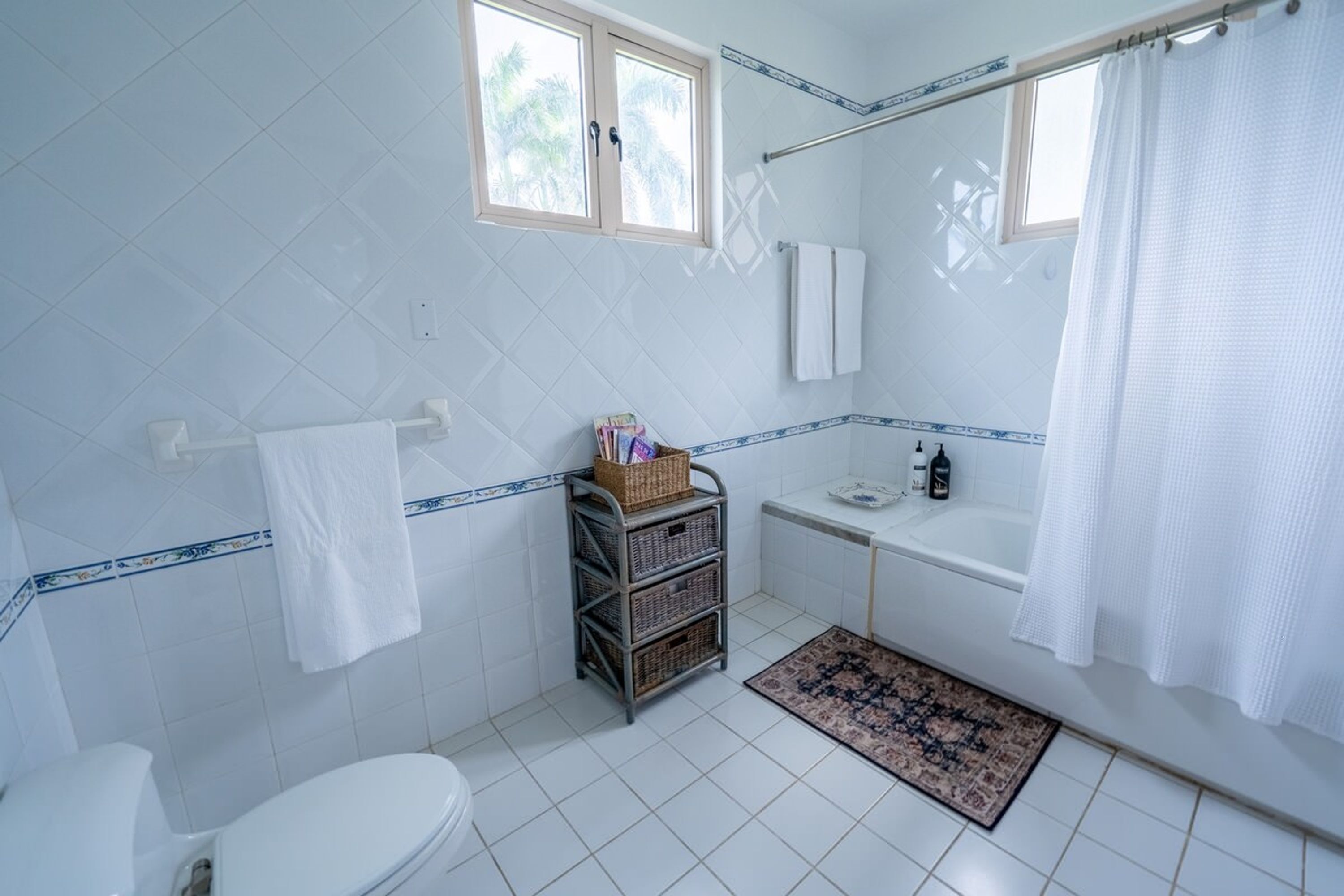 A bathroom with a toilet, a sink, a bathtub, and a window.