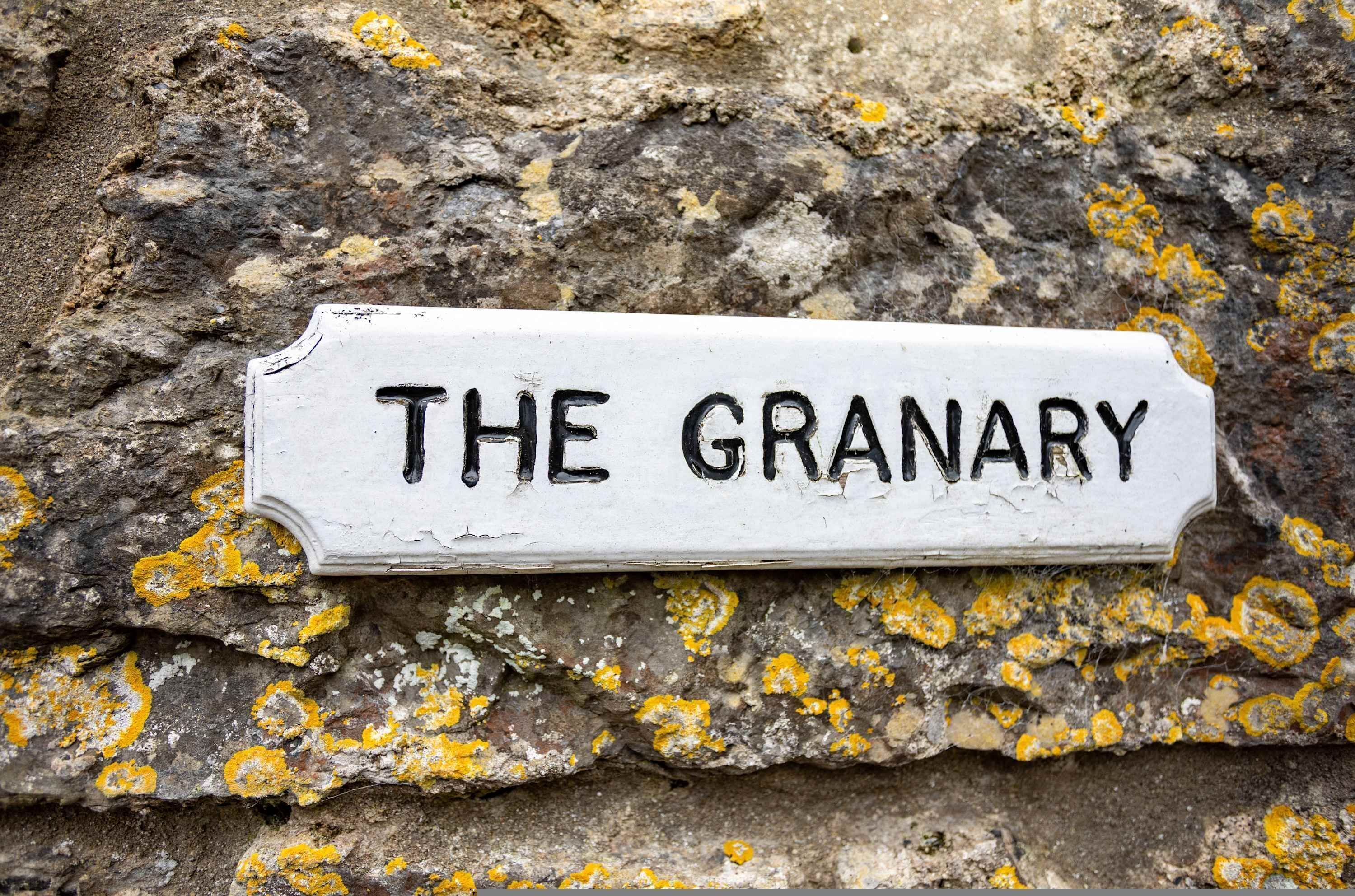 A sign on a stone wall that reads "THE GRANARY."
