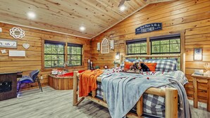 Une chambre confortable, aménagée dans un chalet en bois, avec un lit, un bureau et une chaise.