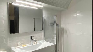 A modern bathroom with a white sink, mirror, and shower. - Fisherman s Albufeira Cosy Studio (Albufeira)