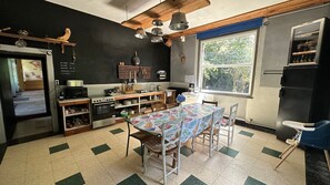 Una cocina con una mesa de comedor, sillas, estufa y refrigerador.