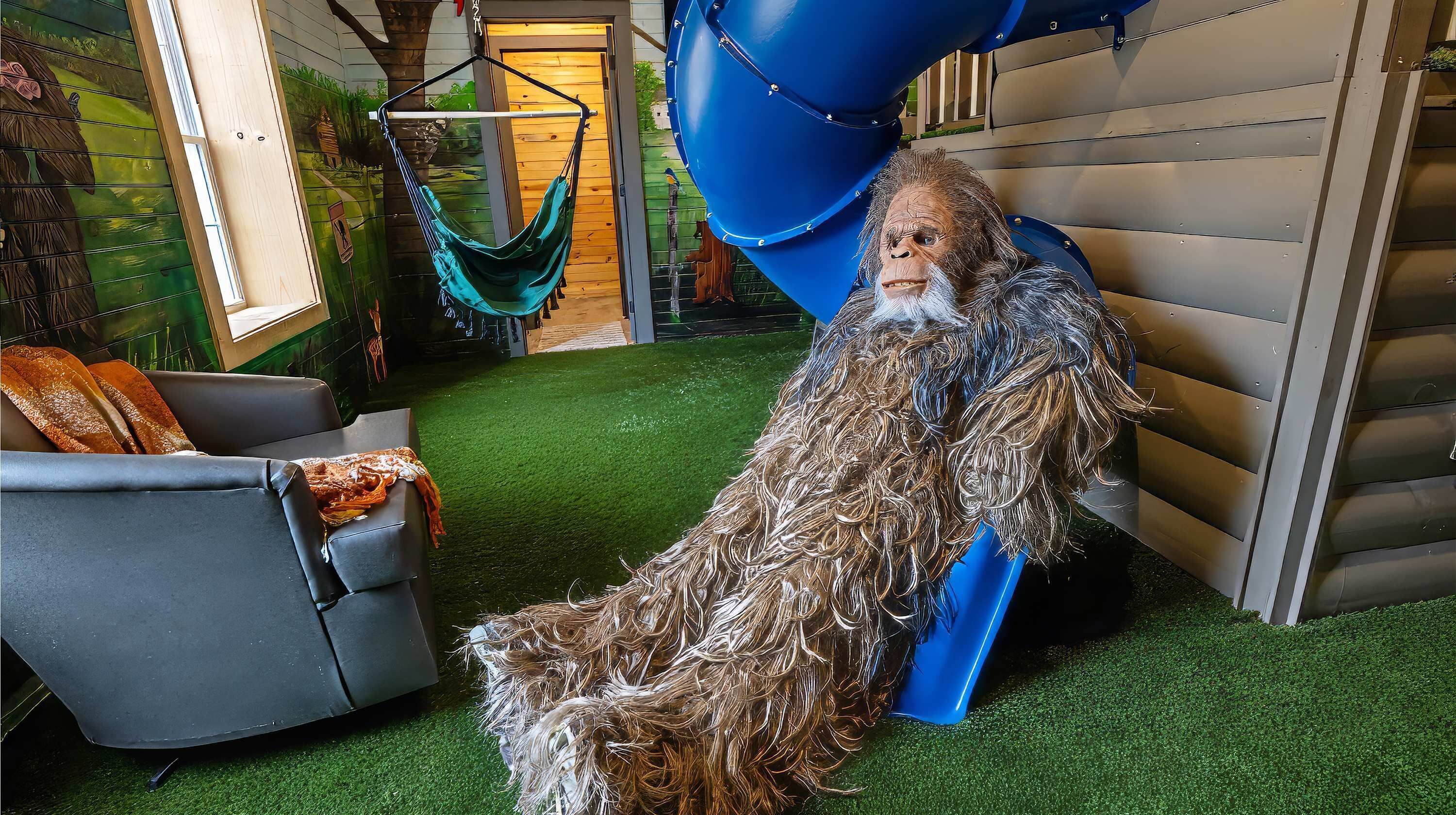 A room with a blue slide, a hammock, and a gray chair.