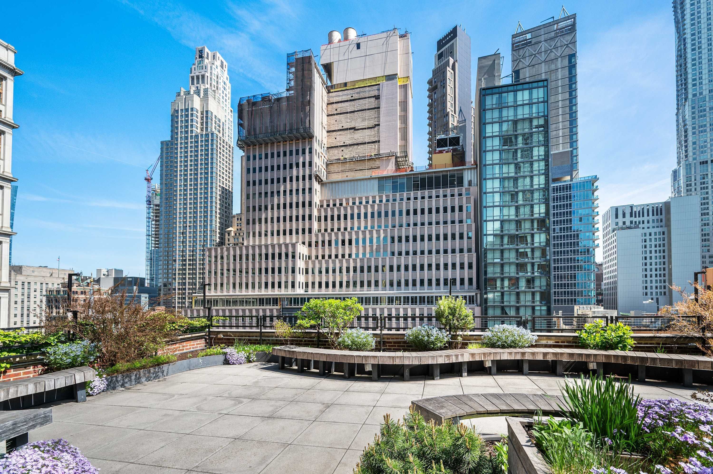 Un edificio moderno con un patio que incluye macetas y zonas de estar.