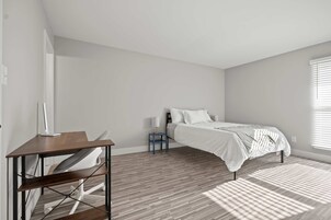 Un dormitorio con cama, escritorio y silla.