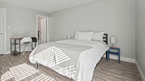 Ein Schlafzimmer mit Bett, Schreibtisch und Stuhl.