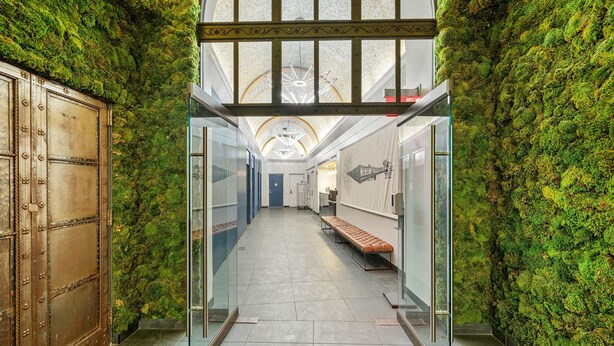 A corridor with a moss-covered wall, a wooden door, and a bench. - 17john: Grand King Studio Apartment (New York)