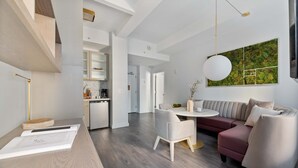 A modern interior with a dining area, a sofa, and a kitchen in the background.