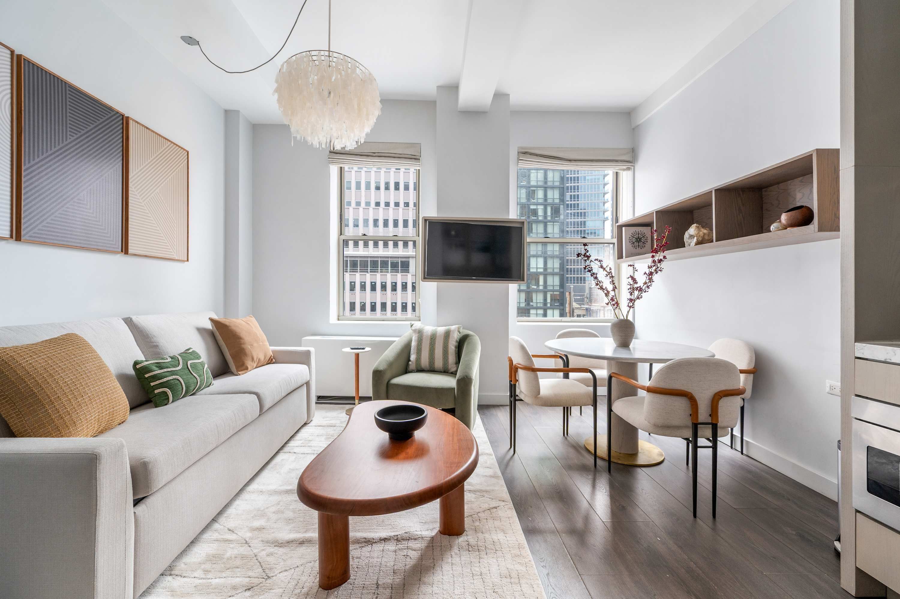 A modern living room with a sofa, coffee table, and dining area.