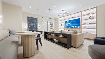 A modern living room with a sofa, a coffee table, a TV, and a bookshelf.