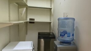 A small kitchenette with a white refrigerator, a stainless steel mini-fridge, and a water dispenser on top of a cabinet. - Family Friendly Villa New Cairo (New Cairo)