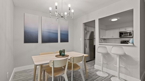 A modern kitchen with white cabinets, a stainless steel refrigerator, and a microwave. - Comfy 2BR 2BA Unit in Pime Location (Rochester)