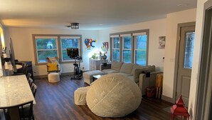 A spacious living area with a large bean bag chair, a dining table with chairs, a sofa, and a TV. - Great Place to Stay When Visiting - Pet Friendly (Rushville)