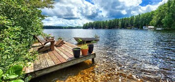 Un muelle de madera que se adentra en un lago, con una embarcación amarrada al final.