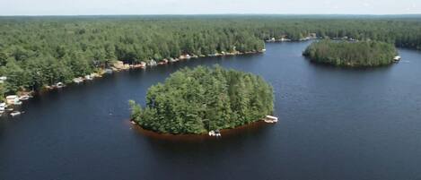An aerial view of a lake surrounded by dense forest with several small islands and docks.