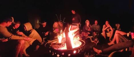 A group of people gathered around a campfire at night.