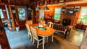 Ein gemütlicher Essbereich mit Holztisch, Stühlen und Pendelleuchten.