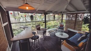 Ein überdachter Außenbereich mit Tisch, Stühlen und einer Couch.