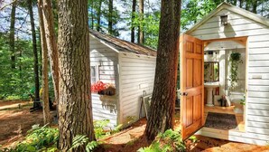 A small cabin with a wooden door and a sign indicating 'Shoes Off'.
