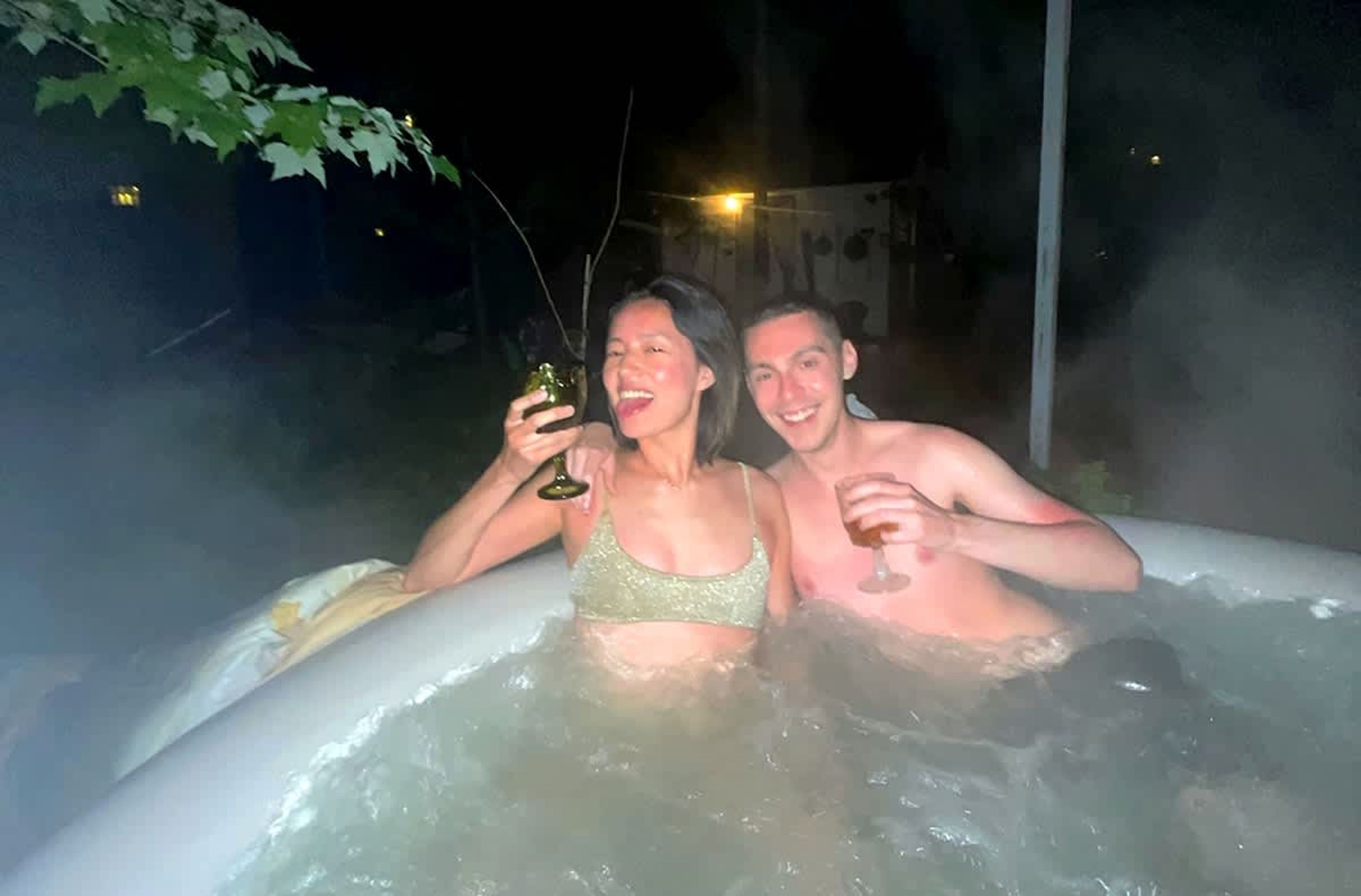 Dos personas en un jacuzzi por la noche.