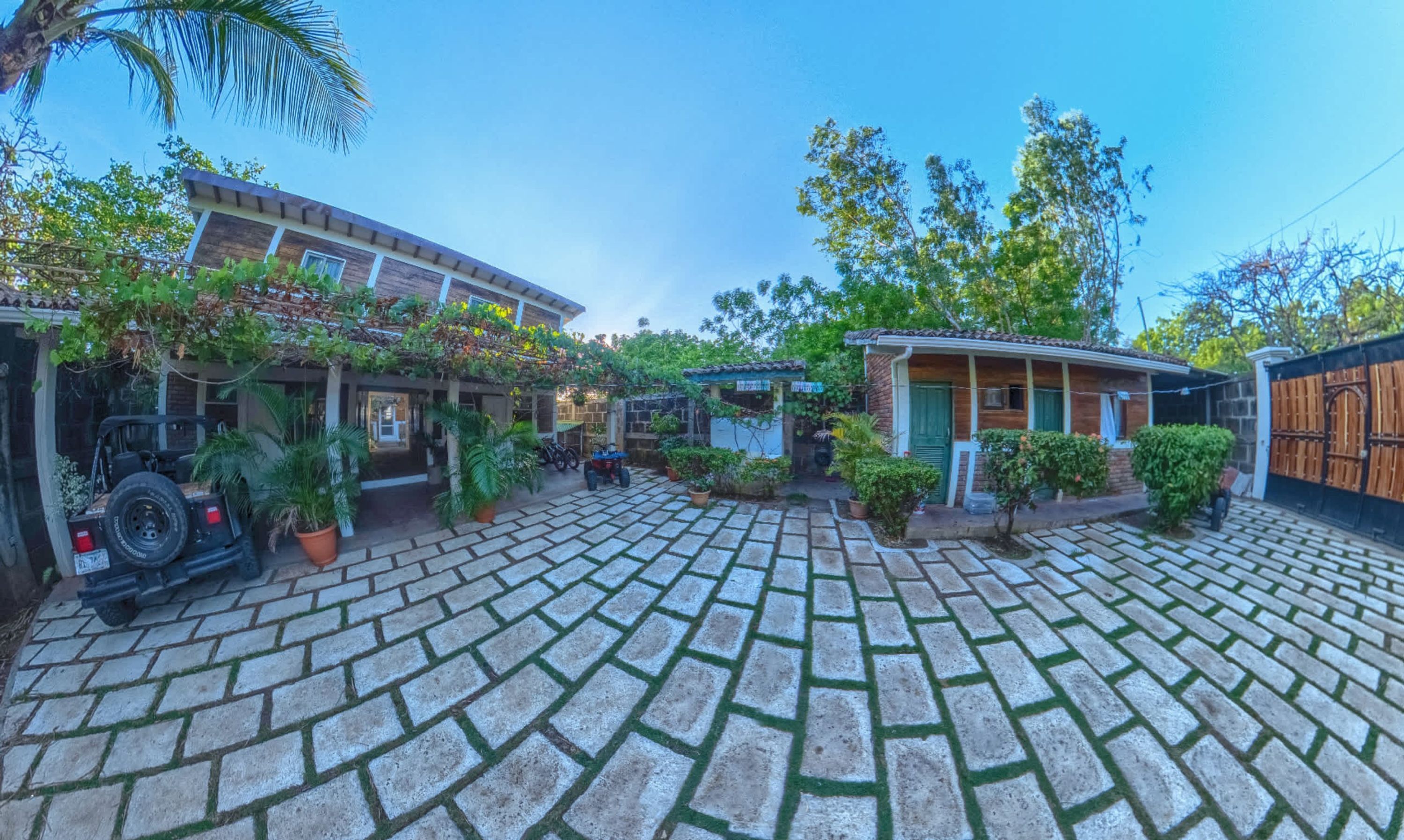 Un patio con un sendero empedrado, rodeado de edificios con terrazas y áreas verdes.